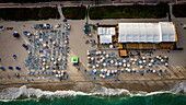 Aerial view of sandy beach with colorful umbrellas and sunbathers, Miami Beach, United States.