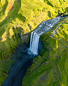 Aerial drone view of Skógafoss waterfall during sunrise in summer time, Southern Iceland.