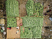 Aerial view of a vibrant street market bustling with people selling fresh watermelons, Dhaka Kotwali Thana, Bangladesh.