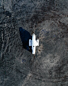 Drohnenansicht des Flugzeugwracks Solheimasandur im schwarzen Sand der Südküste Islands von oben.