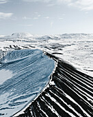 Luftaufnahme eines mit Schnee und Eis bedeckten Vulkankraters, Winterlandschaft im Norden Islands.