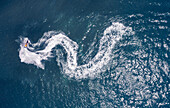 Luftaufnahme eines Wasserfahrrads, das eine weiße, schlangenartige Spur im Wasser bildet, Akko, Nordbezirk, Israel.