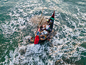 Aerial view of Inani Beach with fishing boats and clear blue ocean waves, Cox's Bazar, Bangladesh.