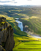 Aerial drone view of Skógafoss waterfall during sunrise in summer time, Southern Iceland.