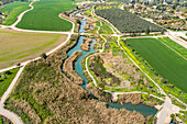 Luftaufnahme von bewirtschafteten Feldern mit Hügeln im Hintergrund und dem Kibbutzim-Bach, Nir David, Nordbezirk, Israel
