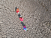 Aerial view of cracked earth with people collecting water in a coastal village, Khulna, Bangladesh.