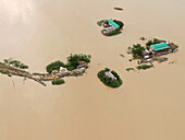 Aerial view of flooded villages surrounded by water with beautiful homes and infrastructure, Balijuri, Tahirpur, Bangladesh.