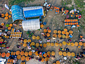 Aerial view of a vibrant winter market with vegetable baskets and people selling fresh potatoes, Brahmanbaria, Bangladesh.