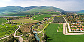 Luftaufnahme von bewirtschafteten Feldern mit Hügeln im Hintergrund und dem Kibbutzim-Bach, Nir David, Nordbezirk, Israel