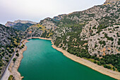 Luftaufnahme des Stausees des Flusses Torrent de Gorg Blau mit seinem grünen Wasser, den Bergfelsen und der ihn umgebenden Vegetation in Escorca, Balearen, Spanien.