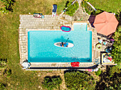 Aerial view of a woman on a SUP or stand up paddle in swimming pool.