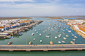 Aerial view of a harbor with the boats docked and a bridge over the Rio Carrera connecting the island of Isla Cristina, Huelva, Spain.