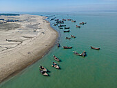 Aerial view of fishing boats at fishery ghat along the serene beach of Bay of Bengal, Cox Bazar, Bangladesh.