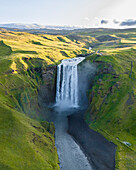 Aerial drone view of Skógafoss waterfall during sunrise in summer time, Southern Iceland.