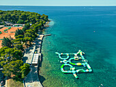 Luftaufnahme von Tennisplätzen und einem Wasserspielplatz für Kinder am Strand von Valkane, Pula, Istrien, Kroatien.