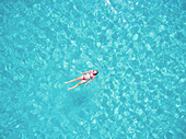 Beautiful woman swimming in transparent sea