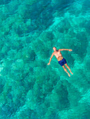 Luftaufnahme eines im adriatischen Meer treibenden Mannes, Sutivan, Insel Brac, Kroatien.
