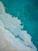 Aerial view of a beautiful beach with algae accumulation and crystal clear turquoise water, Pula, Croatia.