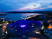 Aerial view of the Pula Amphitheater arena during a concert at sunset, a Roman Amphitheater with underground museum in Pula downtown, Istria, Croatia.