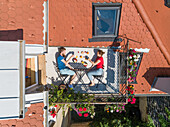 Aerial view of couple having breakfast on roof terrace. Fun concept for people living in the city.