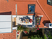 Aerial view of mother and son having breakfast on rooftop balcony.