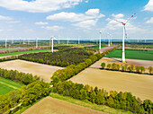 Aerial view of wind turbines, farmland and small forest, Muensterland, Nordrhein-Westfalen, Germany.