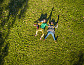Aerial view of family laying down on grass at public playground, Zagreb.