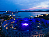 Aerial view of the Pula Amphitheater arena during a concert at sunset, a Roman Amphitheater with underground museum in Pula downtown, Istria, Croatia.
