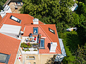 Aerial view of family having breakfast on rooftop balcony in morning sun in Spring.