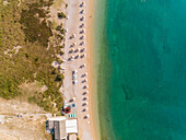 Luftaufnahme von oben der Sonnenschirme am Strand Vela luka, Baska, Insel Krk, Kroatien.