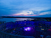Aerial view of the Pula Amphitheater arena during a concert at sunset, a Roman Amphitheater with underground museum in Pula downtown, Istria, Croatia.
