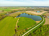 Aerial view of lake Grote Wiel, road with apple trees and river Linge, Rumpt, Betuwe, Gelderland, Netherlands.