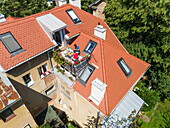 Aerial view of family having breakfast on rooftop balcony in morning sun in Spring.