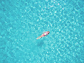 Beautiful woman swimming in transparent sea