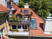 Aerial view of family having breakfast on rooftop balcony in morning sun in Spring.