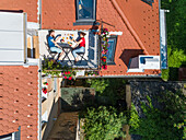 Aerial view of couple having breakfast on roof terrace. Fun concept for people living in the city.