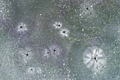 Abstract aerial view of thin layer of ice with cracks and some snow on a small lake after a night of frost, looking like a galaxy, Twente, Overijssel, Netherlands