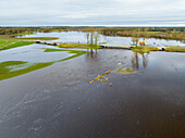 Aerial view of flooded grassland along river Vecht with bridge and weir, Diffelen, Vechtdal, Overijssel, Netherlands.
