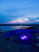 Aerial view of the Pula Amphitheater arena during a concert at sunset, a Roman Amphitheater with underground museum in Pula downtown, Istria, Croatia.