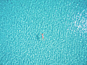 Beautiful woman swimming in transparent sea