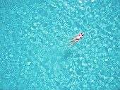 Beautiful woman swimming in transparent sea