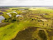 Aerial view of grassland, heather and lakes in nature recovery area Scharreveld, Westerbork, Drenthe, Netherlands.
