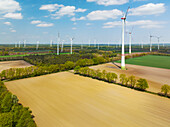 Aerial view of wind turbines, farmland and small forest, Muensterland, Nordrhein-Westfalen, Germany.