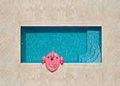Luftaufnahme eines rosa aufblasbaren Flamingos mit Hut am Swimmingpool, Sumartin, Kroatien.