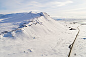 Aerial view of mountain Esja covered with snow and road in winter, capital region of Iceland.