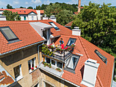 Aerial view of family having breakfast on rooftop balcony in morning sun in Spring.