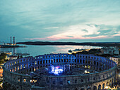 Aerial view of the Pula Amphitheater arena during a concert at sunset, a Roman Amphitheater with underground museum in Pula downtown, Istria, Croatia.