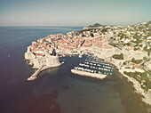 Aerial view of old city of Dubrovnik (Croatia) with old port in front. Dubrovnik is popular tourist attraction on Adriatic. Post processed with vintage filter.