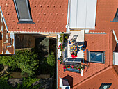 Aerial view of family having breakfast on rooftop balcony in morning sun in Spring.