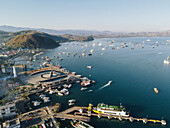 Der Hafen von Labuan Bajo mit einem im Meer segelnden Boot und dem Stadtbild, Touristenziel in Indonesien.